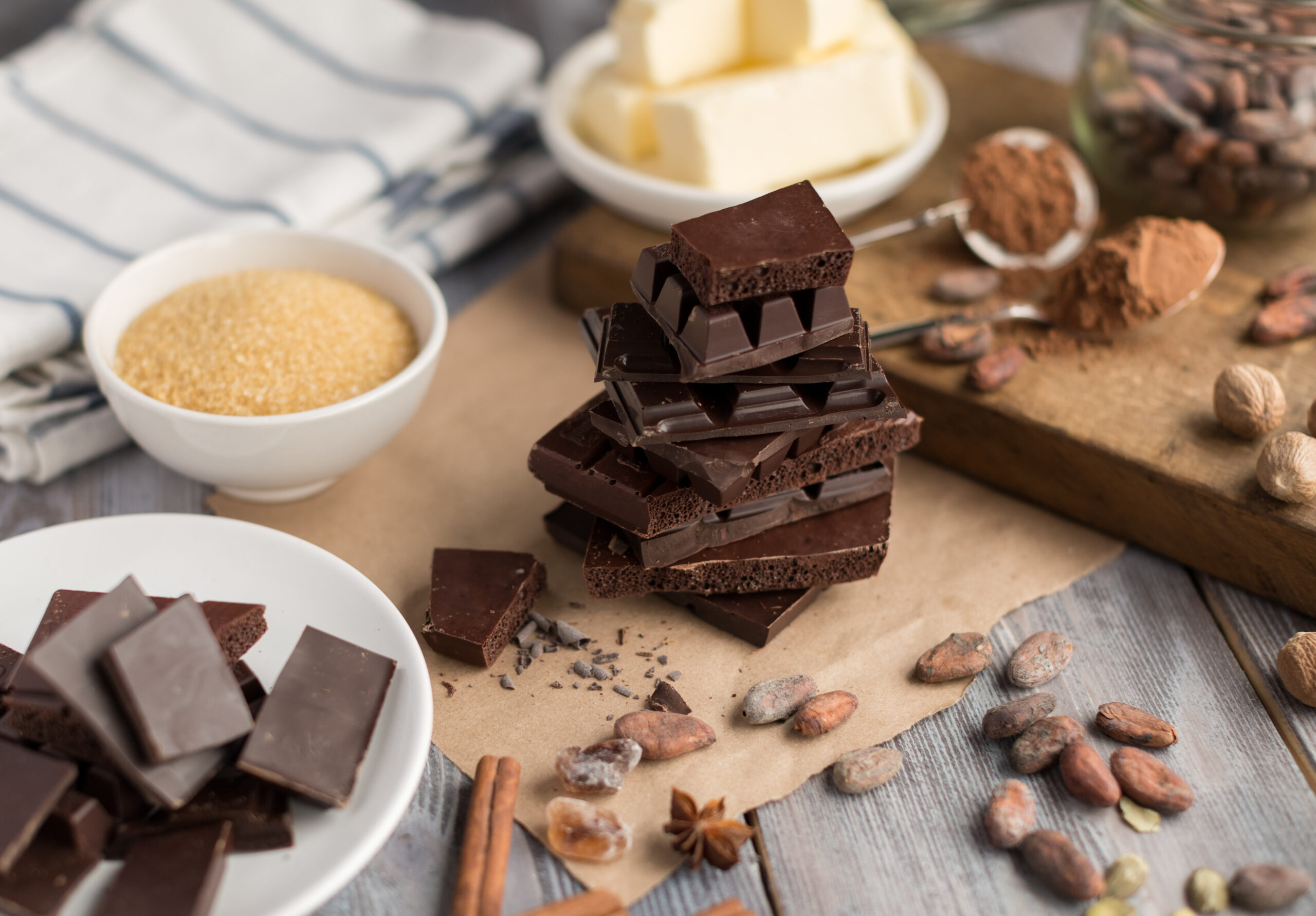 fresh butter, cocoa powder and cocoa beans on the wooden cutting board