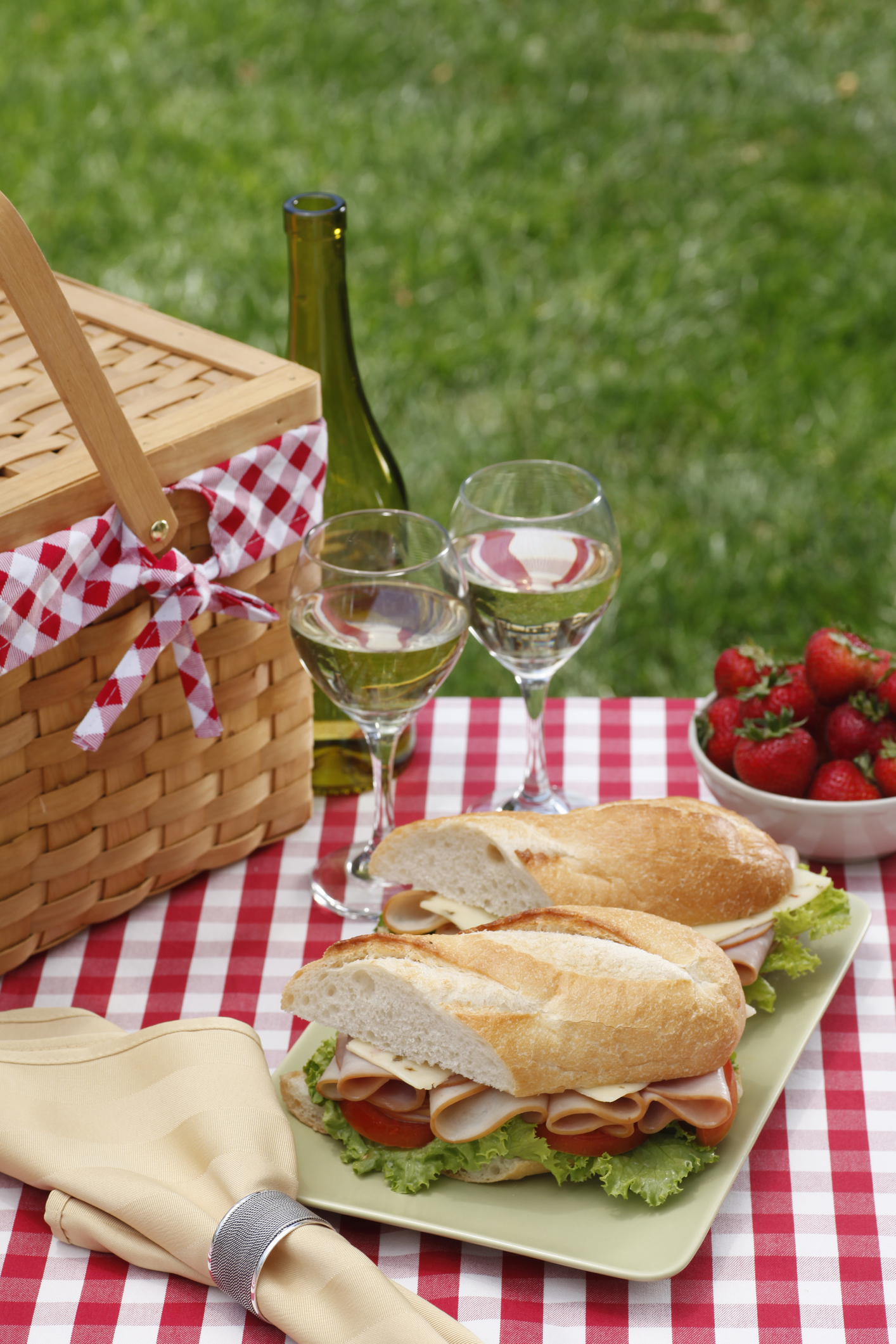 turkey hoagie sandwich sitting on a white picnic table outdoors on a sunny summer day